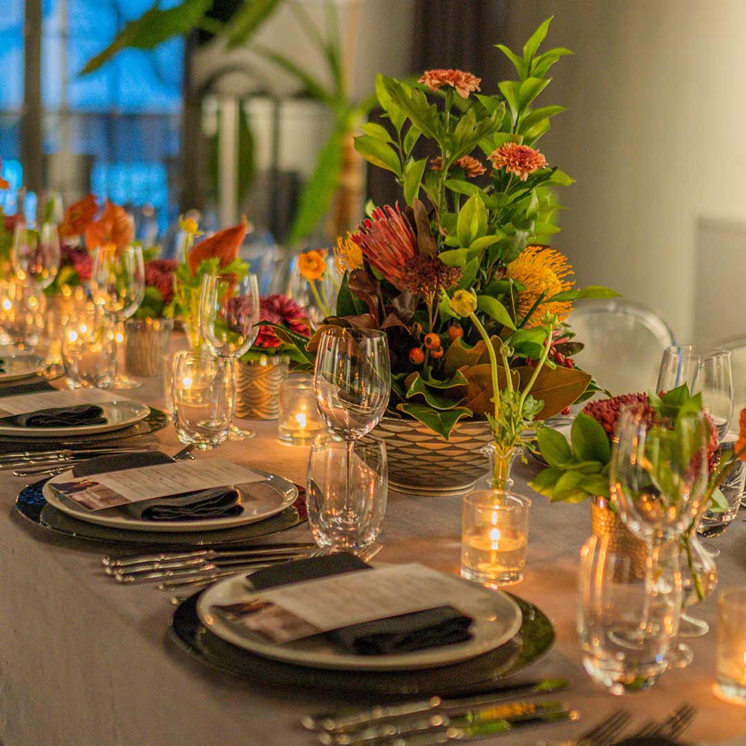 Candlelit corporate dinner with textured autumnal centerpieces